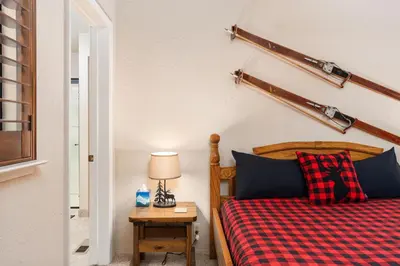 a bedroom with a bed with a red plaid blanket at Rustic Pines- Family Fun Game Cabin in East Village in Shaver Lake
