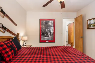 a bedroom with a red and black checkered bed at Rustic Pines- Family Fun Game Cabin in East Village in Shaver Lake