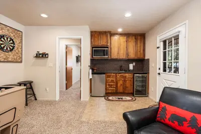 a living room with a couch and a kitchen at Rustic Pines- Family Fun Game Cabin in East Village in Shaver Lake