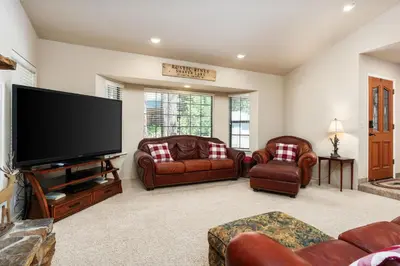 a living room with leather furniture and a flat screen tv at Rustic Pines- Family Fun Game Cabin in East Village in Shaver Lake
