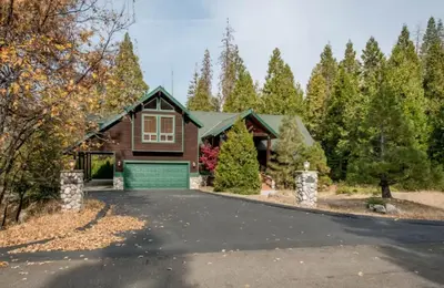 a house with a driveway with a garage at Handels Pride- Family friendly Game Room & Views in Shaver Lake