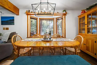 a dining room with a wooden table and chairs at Nana & Papas-Family Friendly in East Village in Shaver Lake
