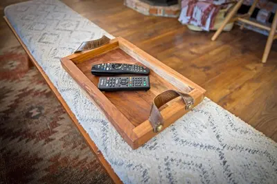 two remote controls sitting on a wooden tray on a table at Nana & Papas-Family Friendly in East Village in Shaver Lake