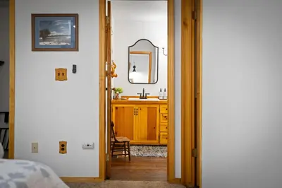 a bedroom with a bathroom with a sink and a mirror at Nana & Papas-Family Friendly in East Village in Shaver Lake