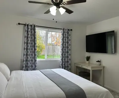 a bedroom with a bed with a ceiling fan and a window at Cozy suite B in Sacramento