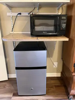 a microwave oven sitting on a shelf with two drawers at Lariat Motel in Sparks