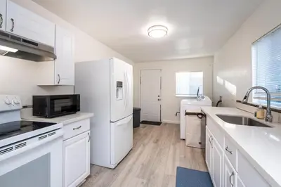 a kitchen with white cabinets and a white refrigerator at 2 Bedroom Home Near Downtown Zoo Golf Pet-Friendly and Fenced in Sacramento