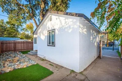 a small white house with a fence and a yard at 2 Bedroom Home Near Downtown Zoo Golf Pet-Friendly and Fenced in Sacramento