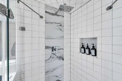 a white tiled shower with three bottles of wine at Northstar Fairway Hot Tub Retreat in Truckee