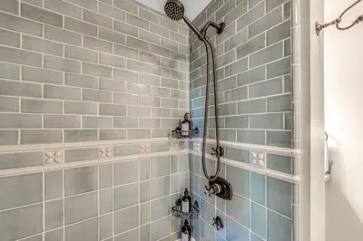 a bathroom with a shower with blue tiles at Lake Tahoe Haven Private Hot Tub Deck in Tahoma