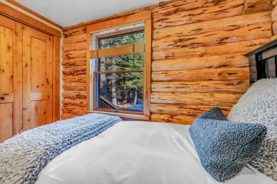 a bedroom with a bed and a wooden wall at Lake Tahoe Haven Private Hot Tub Deck in Tahoma