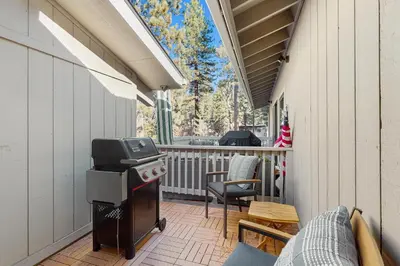 a screened in porch with a grill and chairs at Lakeshore Luxe in Incline Village
