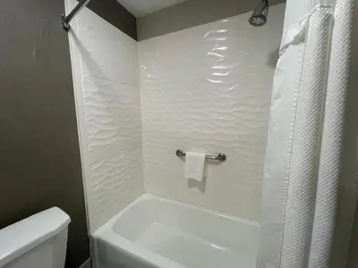 a bathroom with a white tub and a toilet at Sisk Hotel in Modesto