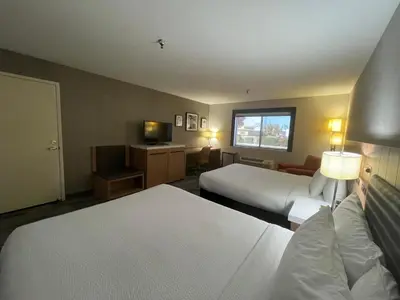 a hotel room with two beds and a television at Sisk Hotel in Modesto