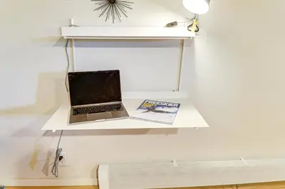 a laptop on a shelf on a wall with a book at 2 Mi to Eagle Lodge! Multi-Level Haven with Hot Tub in Mammoth Lakes