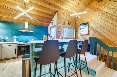 a kitchen with wooden walls and a counter with stools at 2 Mi to Eagle Lodge! Multi-Level Haven with Hot Tub in Mammoth Lakes