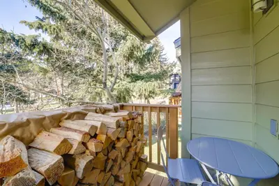 a pile of fire wood on a balcony with a table and chairs at 2 Mi to Eagle Lodge! Multi-Level Haven with Hot Tub in Mammoth Lakes