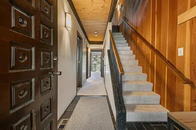 a hallway with stairs and a wooden door at Kingswood Pines in Kings Beach