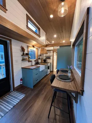 a kitchen with a wooden table in a tiny house at Tiny Rustic at Yosemite Gateway in Groveland