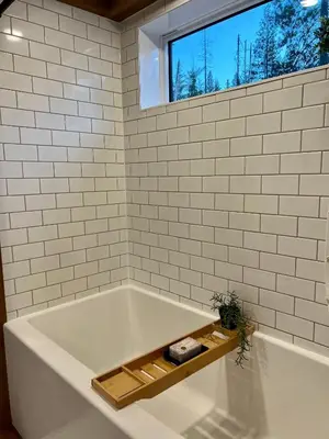 a bathroom with a bath tub with a window at Tiny Rustic at Yosemite Gateway in Groveland