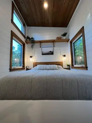 a bedroom in a tiny house with a large bed at Tiny Rustic at Yosemite Gateway in Groveland