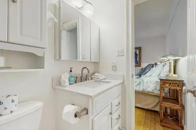 a white bathroom with a sink and a bed at The Treetop Retreat in Incline Village