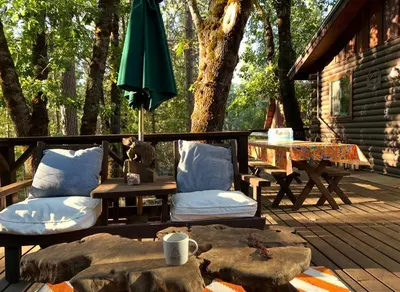 a patio with a table and chairs and an umbrella at 45R Camp Duke in North Wawona