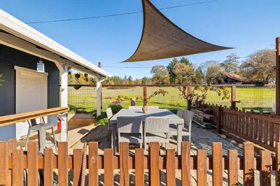 a patio with a table and a fence at Vintage Vine House in Murphys