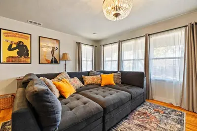 a living room with a gray couch in front of windows at Vintage Vine House in Murphys