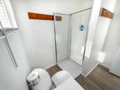 a white bathroom with a shower and a toilet at Boat Dock - Lake Front - Dog Friendly - Sleeps 7 in Bass Lake