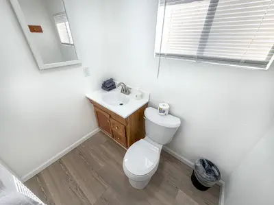 a bathroom with a toilet and a sink and a window at Boat Dock - Lake Front - Dog Friendly - Sleeps 7 in Bass Lake
