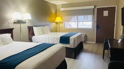 a hotel room with two beds and a window at Rodeway Inn Jackson in Jackson