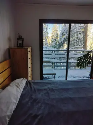 a bedroom with a bed and a window with snow outside at Tahoe Thunderbird Suite with Fireplace in South Lake Tahoe