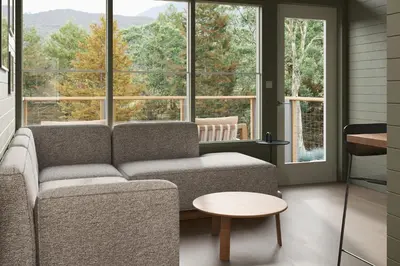 a living room with a couch and large windows at Outbound Yosemite in Oakhurst