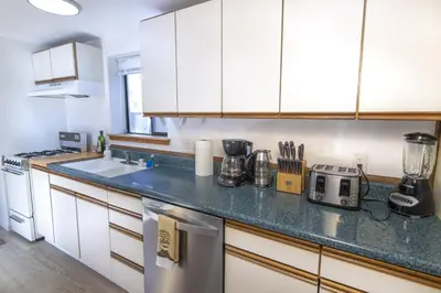 a kitchen with white cabinets and a counter top at Boat Dock - Lake Front - Dog Friendly - Sleeps 23 in Bass Lake