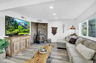 a living room with a large tv and a couch at Yosemite Retreat, Views and Hot Tub in Oakhurst