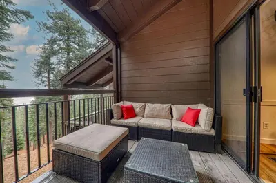 a porch with a couch and a table on a balcony at Newly Remodeled 2Bd 2Ba Condo in NorthStar in Truckee
