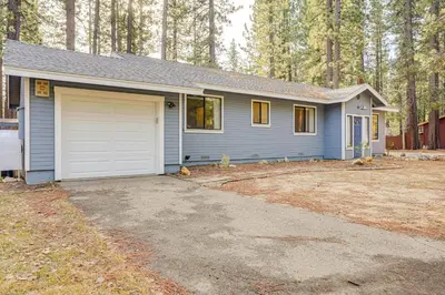 a blue house with a garage in a yard at 5 Mi to Heavenly Resort Cozy Home with Fenced Yard in South Lake Tahoe
