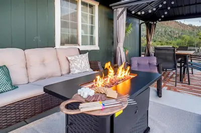 a living room with a fire pit on a patio at Cold Plunge, Hot Tub, Firepit, BBQ, Pet-Friendly, Sunset Views near Yosemite in Coarsegold