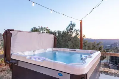 a jacuzzi tub sitting on top of a balcony at Cold Plunge, Hot Tub, Firepit, BBQ, Pet-Friendly, Sunset Views near Yosemite in Coarsegold