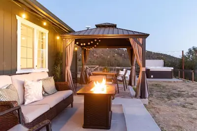 a gazebo with a couch and a table on a patio at Cold Plunge, Hot Tub, Firepit, BBQ, Pet-Friendly, Sunset Views near Yosemite in Coarsegold