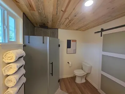 a bathroom with a toilet and a towel at Skyfalls Retreat Mid-Century Guesthouse near Yosemite in Oakhurst