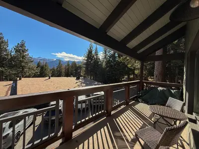 a deck with two chairs and a view of the mountains at Chateau Doex #8 condo in Mammoth Lakes