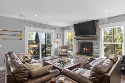 a living room with a leather couch and a fireplace at Lakeview Luxury Retreat with Hot Tub and Game Room in Carnelian Bay