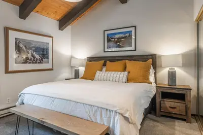 a bedroom with a large bed with yellow pillows at Mammoth Creek 36 in Mammoth Lakes