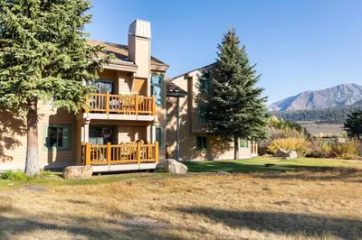 a large house with a deck and mountains in the background at Mammoth Creek 36 in Mammoth Lakes