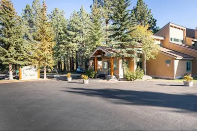 a house with a parking lot in front of trees at Mammoth Creek 36 in Mammoth Lakes