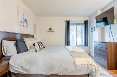 a bedroom with a bed and a dresser and a window at Summit 240 in Mammoth Lakes