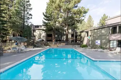 a large swimming pool with blue water in a yard at Summit 240 in Mammoth Lakes