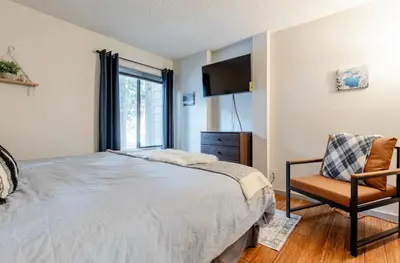 a bedroom with a large bed and a chair at Summit 240 in Mammoth Lakes
